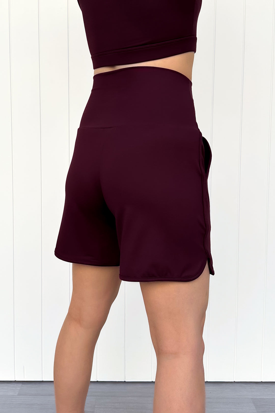 Maroon athletic shorts worn by a person on a white background