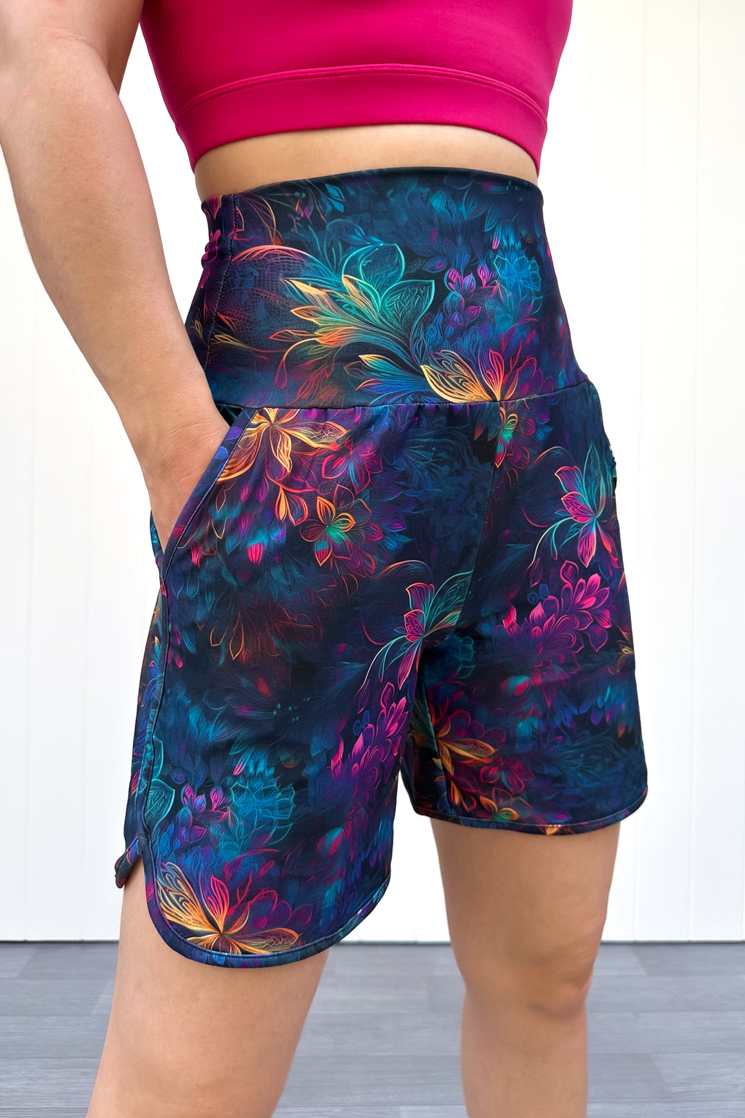 Colorful floral-patterned shorts worn by a person against a white background