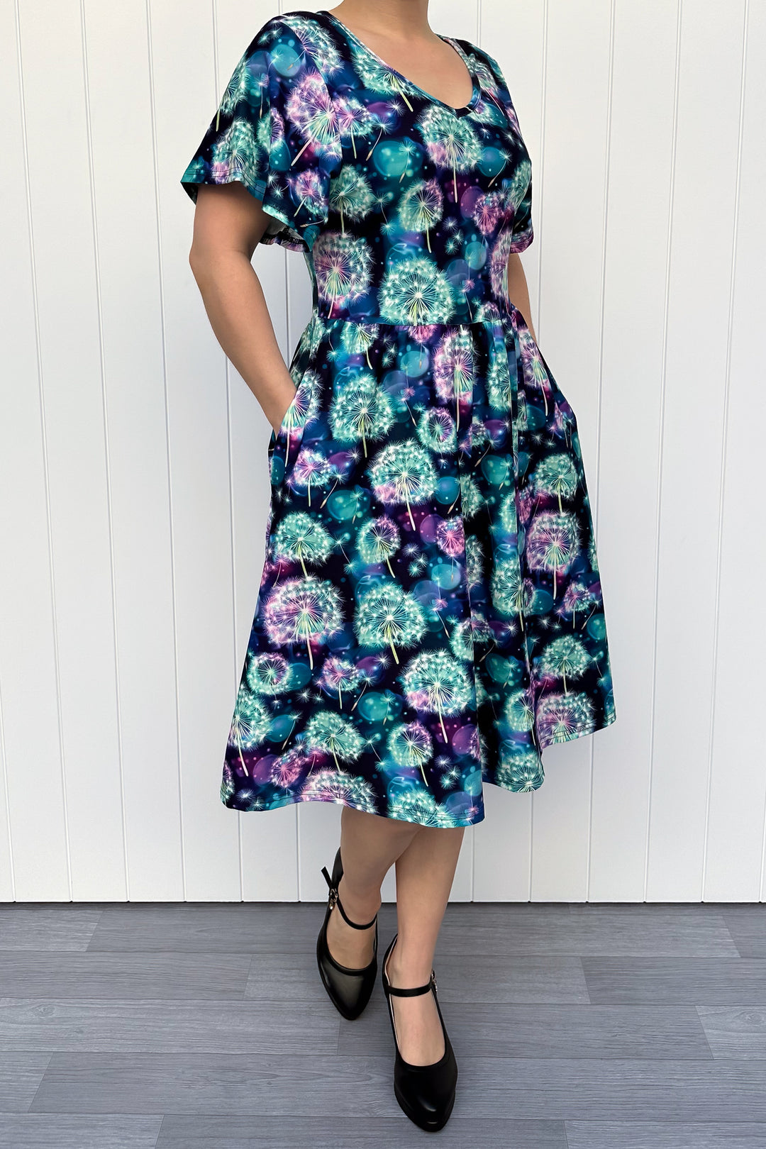 Woman wearing a colorful floral dress with a white background