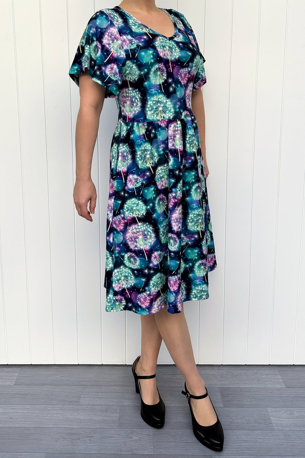 Woman wearing a floral dress with a white wooden background